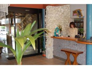 une femme debout au comptoir d'un restaurant dans l'établissement Amami Resort Bashayamamura / Vacation STAY 81475, à Amami