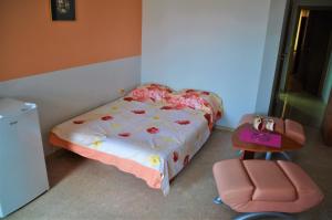 a small bedroom with a bed and a chair at Sozopol House Dimitrakievi in Sozopol