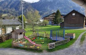 un parque infantil con tobogán y columpio en Apartments Hänsler, en Mellau