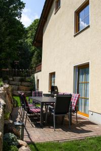 una mesa y sillas frente a una casa en Ferienwohnung Julia, en Kurort Gohrisch