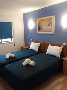 a bedroom with two beds with towels on them at "A Casa dos Avôs" Suites & Breakfast in Lagos