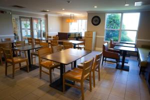 a restaurant dining room with tables and chairs at Country Inn & Suites by Radisson, Burlington Elon , NC in Burlington