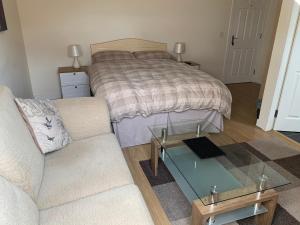 a living room with a bed and a couch and a glass table at Crayford's Guest House in Aberdeen