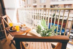 聖塞巴斯提安的住宿－GROS ZURRIOLA BEACH WIFI TERRACE PARKING 20E night，阳台配有带水果和橙汁的桌子。