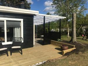 een houten terras met twee stoelen op een huis bij Hyggeligt sommerhus i Ebeltoft, tæt på strand og skov. in Ebeltoft