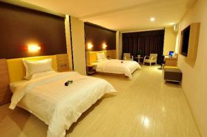 a hotel room with two beds and a living room at 7Days Premium Xi'an Xiaozhai Metro Station Jinsha in Xi'an