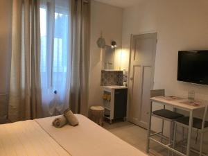 a bedroom with a bed and a television and a desk at Le Marty in Narbonne