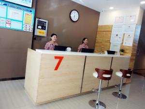 two people sitting at a counter with their laptops at 7 Days Premium Hami City Government Branch in Hami
