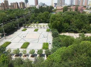 uma vista aérea de um parque com uma cidade ao fundo em 7 Days Premium Hami City Government Branch em Hami