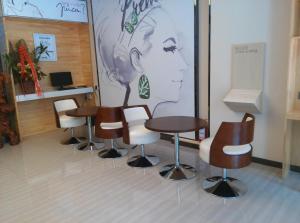 uma sala de espera com mesas e cadeiras e um mural em 7 Days Premium Hami City Government Branch em Hami