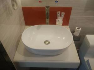 lavabo blanco sentado en una encimera en el baño en 7Days Premium Meizhou Fengshun Store en Tangkeng