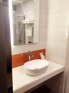 a bathroom with a white sink and a mirror at 7Days Premium Meizhou Fengshun Store in Tangkeng