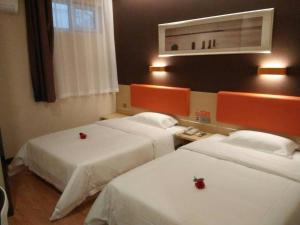 um quarto de hotel com duas camas com maçãs vermelhas em 7Days Premium Jinan Shanghe Yujing City Branch em Shang-ho-hsien