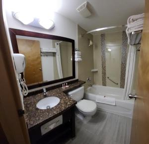 a bathroom with a sink and a toilet and a tub at SureStay by Best Western Richmond Vancouver Airport in Richmond +35 photos