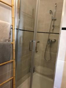 La salle de bains est pourvue d'une douche avec une porte en verre. dans l'établissement Le Marty, à Narbonne
