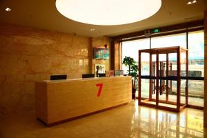 un vestíbulo con un mostrador de madera con un número en 7Days Premium Gongzhuling Railway Station Branch, en Siping