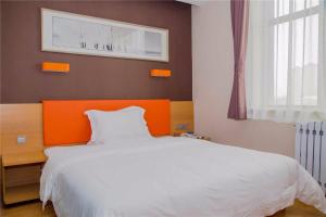 um quarto com uma cama branca e uma cabeceira laranja em 7Days Premium Shijiazhuang East Railway Station Shenghe Square Branch em Shijiazhuang