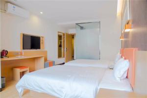 a bedroom with a large white bed and a tv at 7Days Premium Shijiazhuang East Railway Station Shenghe Square Branch in Shijiazhuang