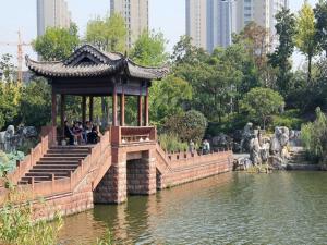 un cenador en un parque junto a un estanque en 7Days Premium Huanggang Walking Street Branch en Huangzhou