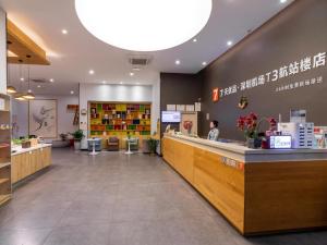 a lobby of a store with a counter and a person at 7Days Premium Shenzhen Airport T3 Terminal Branch in Shenzhen