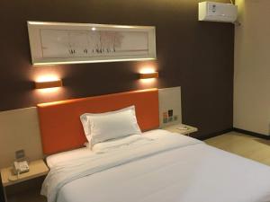 1 dormitorio con 1 cama blanca grande y cabecero naranja en 7Days Premium Shijiazhuang Luquan Shangzhuang Branch, en Shijiazhuang