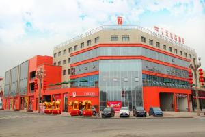 a large building with cars parked in front of it at 7Days Premium Leshan Qianwei Fengye Fortune Center Branch in Leshan