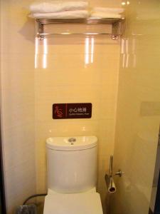 a bathroom with a toilet with a sign above it at 7Days Premium Leshan Qianwei Fengye Fortune Center Branch in Leshan