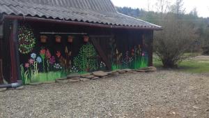 a painting of flowers on the side of a building at Salamandra in Krempna