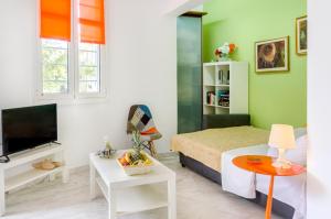 Habitación pequeña con cama y TV. en Garden House Palaio Faliro en Atenas