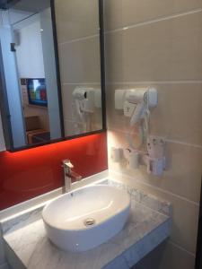 a bathroom with a white sink and a mirror at 7Days Premium Wuzhong Wanda Plaza Branch in Wuzhong