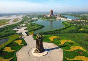 a view of a park with a statue and a lake at 7Days Premium Wuzhong Wanda Plaza Branch in Wuzhong