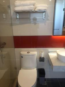 uma casa de banho com um WC branco e um lavatório. em 7Days Premium Wuzhong Wanda Plaza Branch em Wuzhong