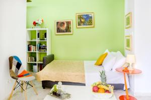 アテネにあるGarden House Palaio Faliroのベッドルーム1室(ベッド1台付)、床にフルーツを用意したテーブルが備わります。