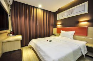 a hotel room with a large white bed in it at 7Days Premium Qinghuangdao Hebei Avenue Sidaoqiao Branch in Qinhuangdao