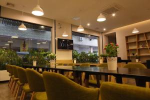 ein Restaurant mit einem Tisch, Stühlen und Pflanzen in der Unterkunft 7 Days PremiumQingyuan Yinzhan Hot Springs [High-end Budget Hotel] in Zhuyuan