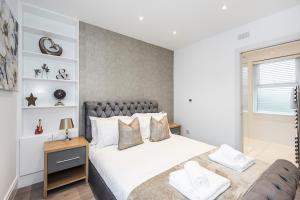 ein Schlafzimmer mit einem großen Bett und einem Sofa in der Unterkunft Cozy and Serene brand-new flat in Kilburn, London in London
