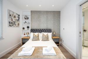 a bedroom with a large bed with two towels at Cozy and Serene brand-new flat in Kilburn, London in London