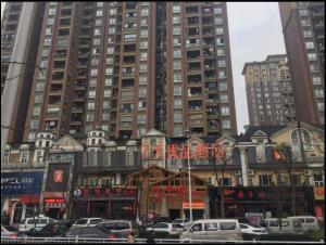 miasto z wysokimi budynkami i samochodami zaparkowanymi przed w obiekcie 7Days Premium Yibin Riverside Branch w Yibin