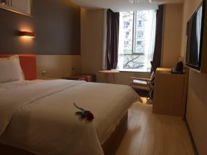 a hotel room with a bed with a flower on it at 7Days Premium Yibin Riverside Branch in Yibin