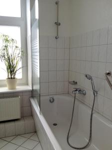 Das Bad ist mit einer Badewanne mit einer Dusche ausgestattet. in der Unterkunft Ferienwohnung am Schlossparkcenter in Schwerin