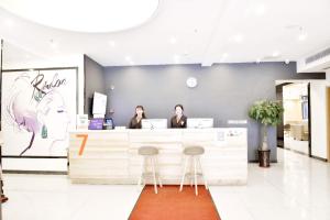 deux femmes assises à un comptoir dans un salon dans l'établissement 7Days Premium Chongqing Tongliang District Government Pedestrian Street Branch, à Tongliang