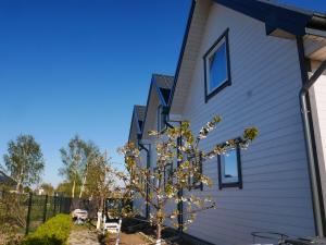 ein Haus mit einem Baum davor in der Unterkunft Domki Noce i dnie in Władysławowo