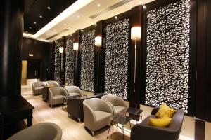 a waiting room with chairs and tables and a wall at Le Corail Suites Hotel in Tunis