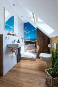 een badkamer met een wastafel en een douche met uitzicht op het strand bij Dein Sylt in Westerland