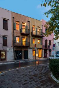 un edificio con balcones al lado de una calle en Polixeny's Suites en La Canea