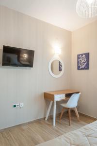 a bedroom with a desk and a chair and a mirror at ANEMOLIA in Agios Ioannis Kaspaka