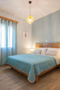a bedroom with a large bed and a chandelier at ANEMOLIA in Agios Ioannis Kaspaka