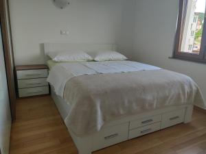 - une chambre avec un lit doté de draps blancs et une fenêtre dans l'établissement Panoramic view apartments Crikvenica, à Crikvenica