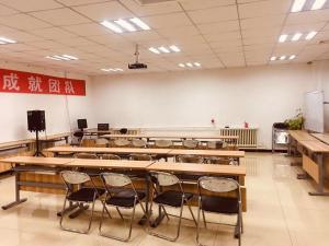 un aula vacía con escritorios y sillas en una habitación en 7Days Premium Baoding Qingyuan Jianshe North Road Branch, en Baoding