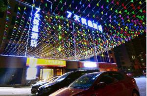 a group of cars parked in front of a building with lights at 7Days Premium Guang'an Chaoyang Avenue Branch in Guang'an